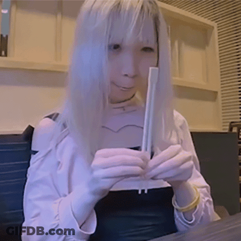 Woman With Long Blonde Hair Holding Chopsticks GIF