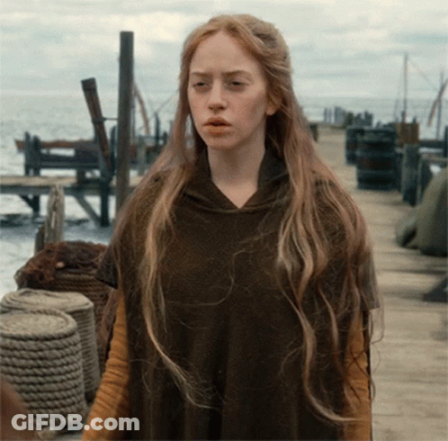 Woman With Long Blonde Hair Wearing Brown Poncho GIF