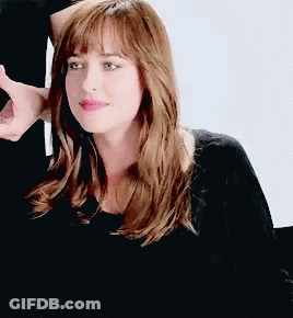 Woman With Long Brown Hair And Bangs In Black Shirt GIF