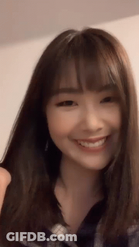 Woman With Long Brown Hair And Bangs Smiling GIF