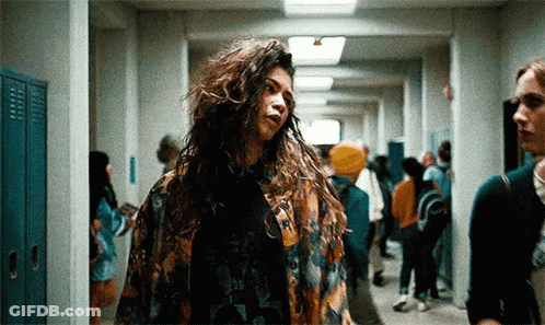 Woman With Long Curly Hair In Hallway With Lockers GIF
