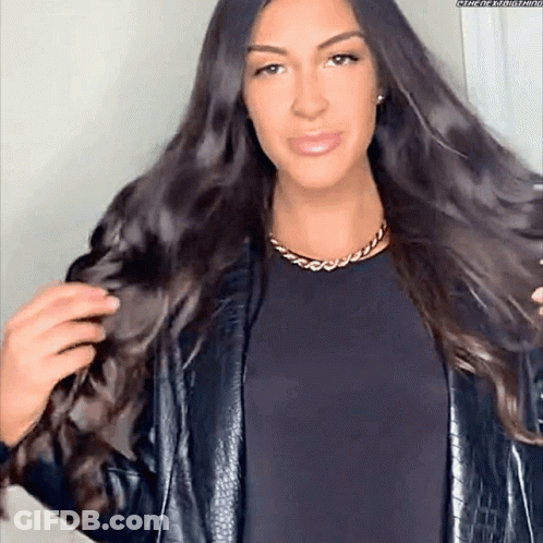 Woman With Long Dark Hair In Black Jacket And Gold Chain GIF