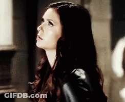 Woman With Long Dark Hair In Black Jacket Looking Up GIF