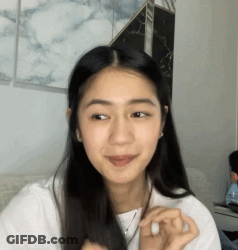 Woman With Long Dark Hair Looking At Camera GIF