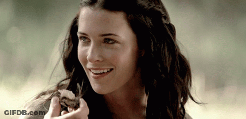 Woman With Long Dark Hair Smiling Holding Food GIF