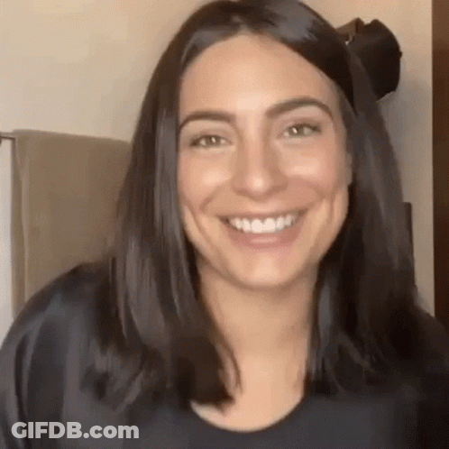 Woman With Long Dark Hair Smiling In Bathroom GIF
