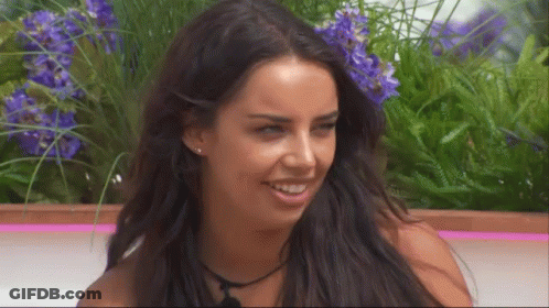 Woman With Long Dark Hair Smiling Purple Flowers GIF