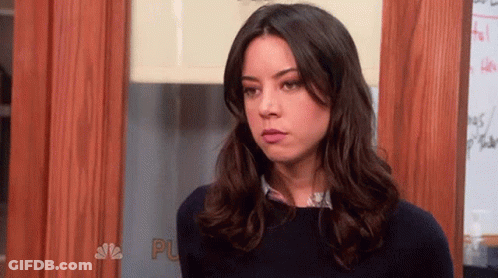 Woman With Long Dark Hair Standing In Front Of Door GIF