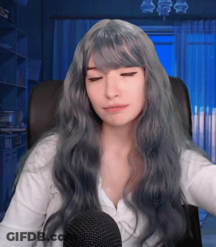 Woman With Long Grey Hair Sitting At Microphone Eyes Closed GIF