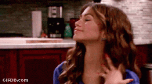 Woman With Long Hair Eyes Closed In Kitchen GIF