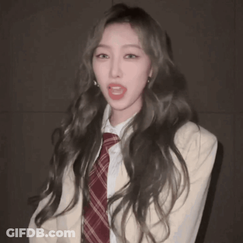 Woman With Long Hair In Plaid Tie And White Jacket GIF