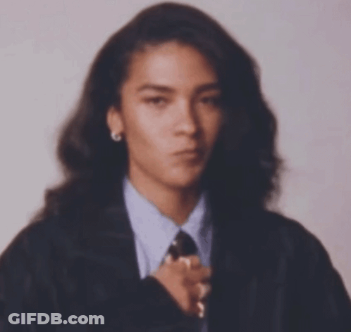 Woman With Long Hair In Suit And Tie Looking At Camera GIF