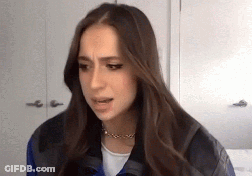 Woman With Long Hair Making Funny Face In Leather Jacket And Necklace GIF