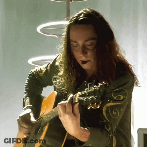 Woman With Long Hair Playing Guitar With Swirl Jacket GIF