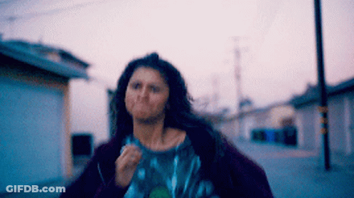 Woman With Long Hair Running Down Street GIF