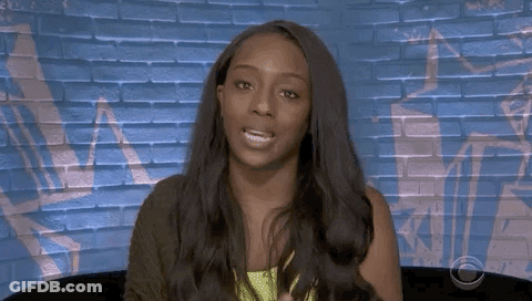 Woman With Long Hair Sitting In Front Of Brick Wall GIF