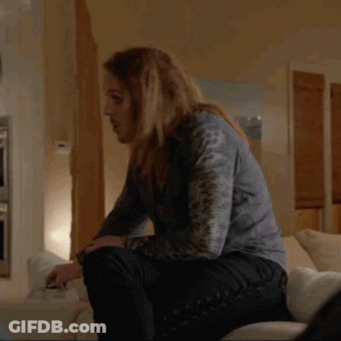 Woman With Long Hair Sitting On Couch Holding Glass GIF