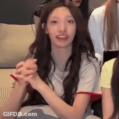 Woman With Long Hair Sitting On Couch Holding Hands GIF