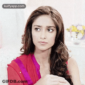 Woman With Long Hair Sitting On Couch Looking At Camera GIF