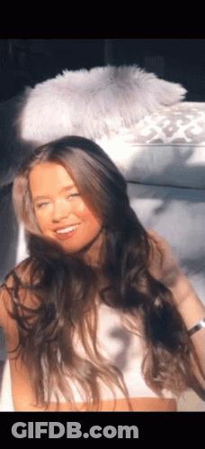 Woman With Long Hair Sitting On White Couch GIF