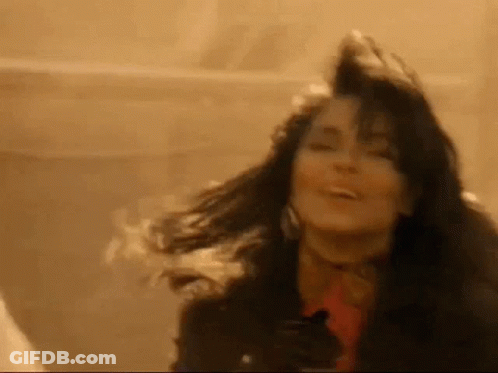 Woman With Long Hair Smiling Holding Gun GIF