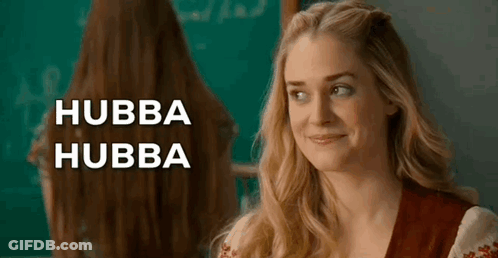 Woman With Long Hair Smiling In Front Of Blackboard And Mirror GIF