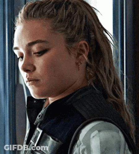 Woman With Long Hair Standing In Front Of Window Wearing Vest GIF