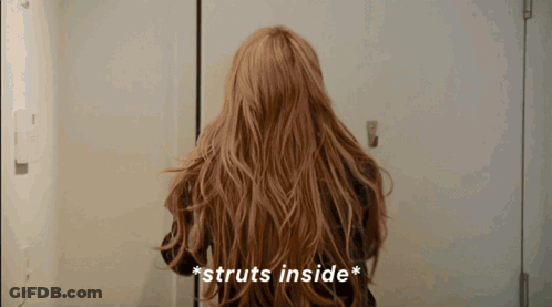 Woman With Long Hair Struts Inside Door GIF