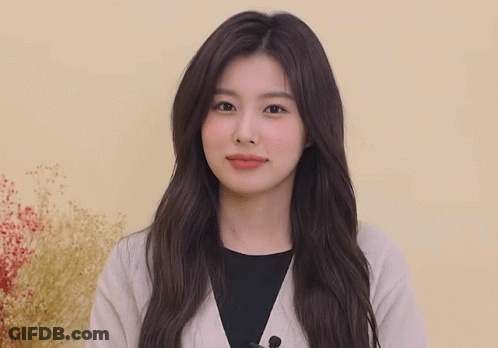 Woman With Long Hair Waving Hands In Front Of Yellow Wall GIF