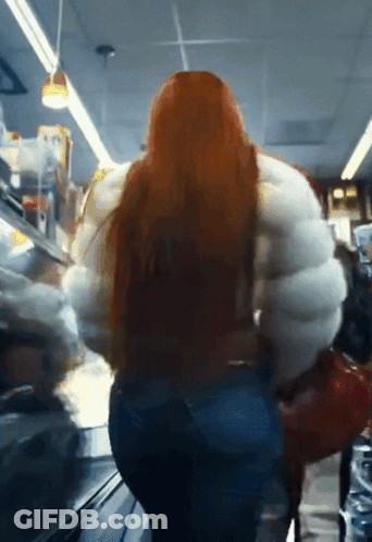 Woman With Long Red Hair In Large White Jacket GIF