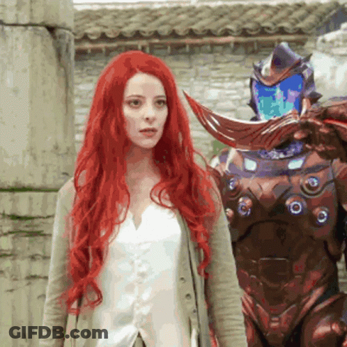 Woman With Long Red Hair Next To Robot GIF