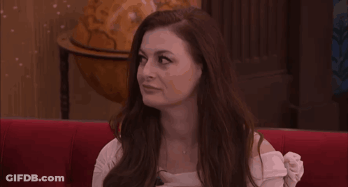 Woman With Long Red Hair On Red Couch With Globe GIF