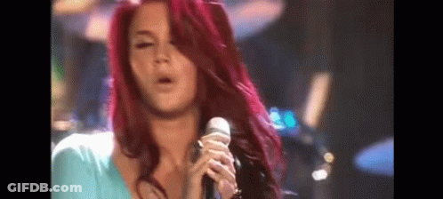 Woman With Long Red Hair Singing Into Microphone GIF