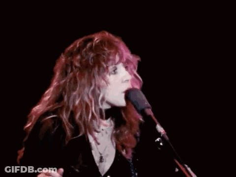 Woman With Long Red Hair Singing Into Microphone GIF