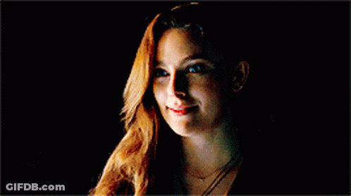 Woman With Long Red Hair Smiling In Dark GIF