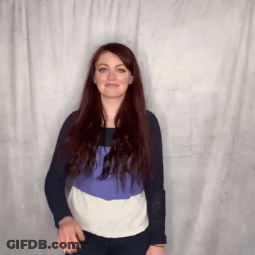 Woman With Long Red Hair Standing In Front Of Curtain GIF