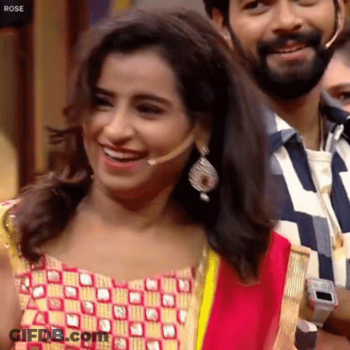 Woman With Microphone Smiling Beside Bearded Man GIF
