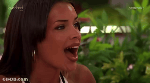 Woman With Mouth Open Sitting By Green Plant GIF