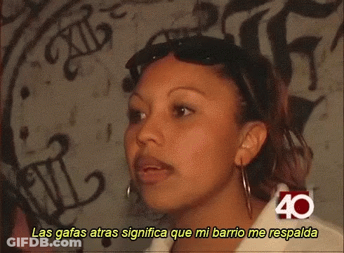 Woman With Mustache Wearing Sunglasses And Shirt Saying Las Gafas Atras Significa Que Mi Barrio Me Respald GIF