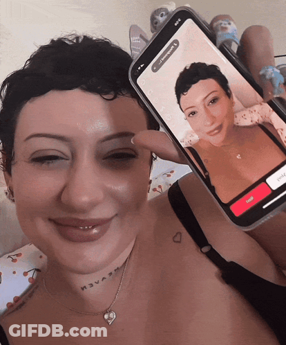 Woman With Neck Tattoo Holding Phone With Another Woman GIF