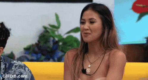 Woman With Necklace On Yellow Couch With Others GIF
