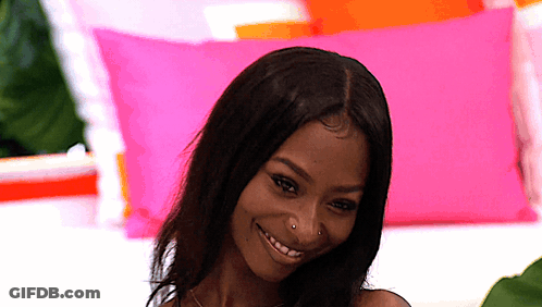 Woman With Nose Ring Smiling With Pink And Orange Pillows GIF