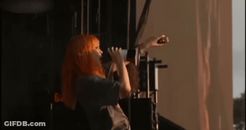 Woman With Orange Hair Singing Into Microphone GIF