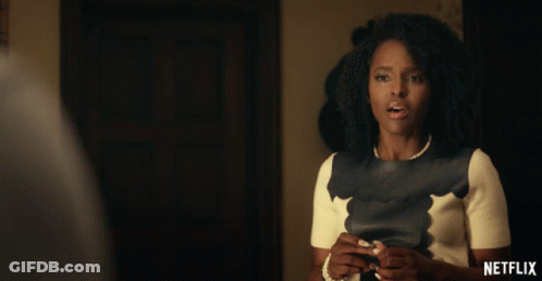 Woman With Pearl Necklace In Front Of Netflix Sign GIF