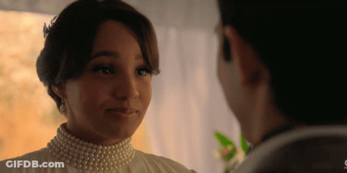 Woman With Pearls Looking At Man GIF