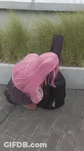 Woman With Pink Hair Kneeling Beside Guitar Case GIF