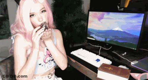 Woman With Pink Hair Sits At Computer With Cross Book GIF