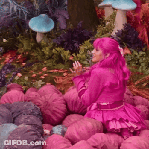 Woman With Pink Hair Sitting In Pink Flowers GIF