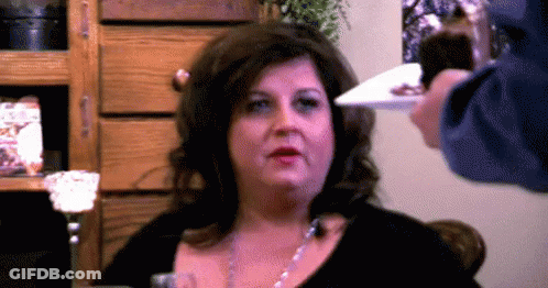 Woman With Plate In Front Of Face GIF