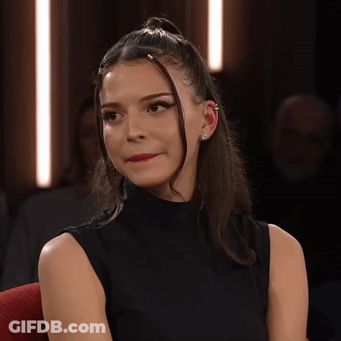 Woman With Ponytail And Ear Piercing Looking At Camera GIF